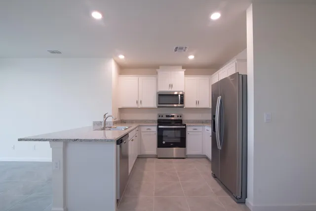 a kitchen with refrigerator and cabinets