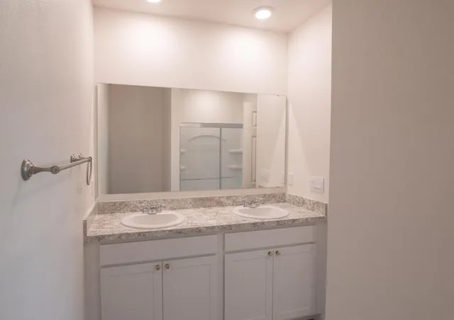 a bathroom with a granite countertop sink and a mirror