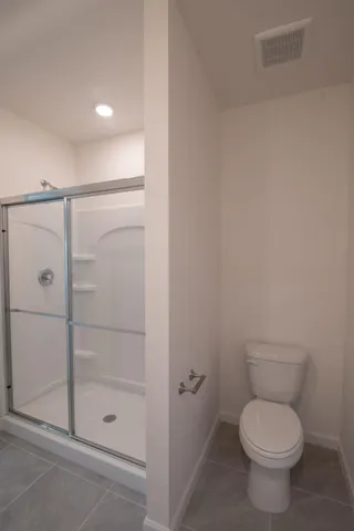 a bathroom with a toilet and a shower