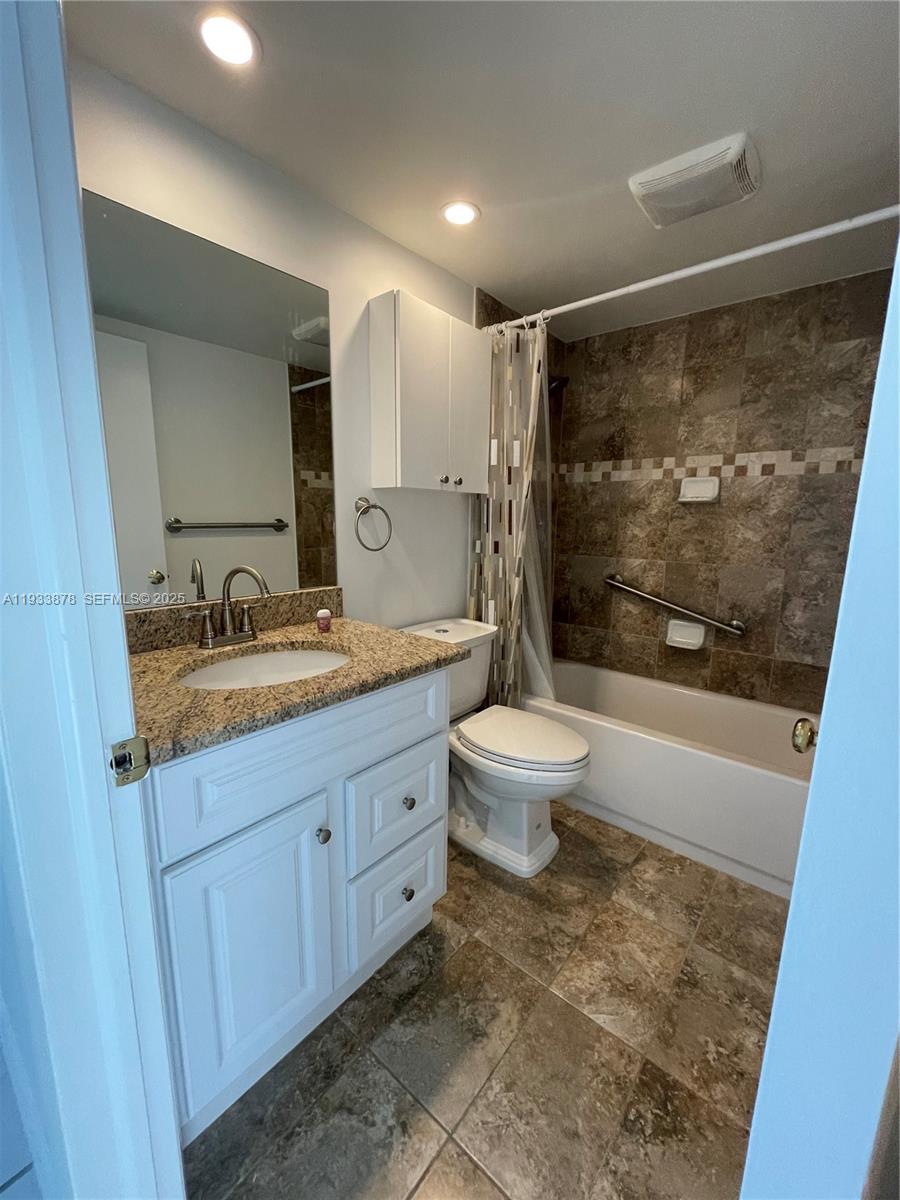 485 Flanders P, Unit 485 Delray Beach, FL 33484 - Photo 15 of 42 a bathroom with a granite countertop sink toilet and shower