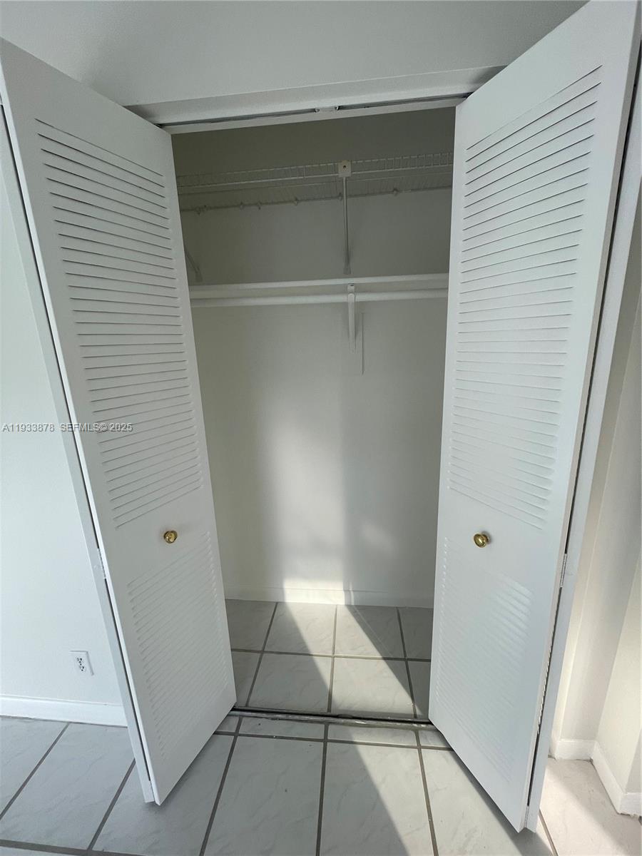 485 Flanders P, Unit 485 Delray Beach, FL 33484 - Photo 28 of 42 a room with a walk in closet and wooden floor