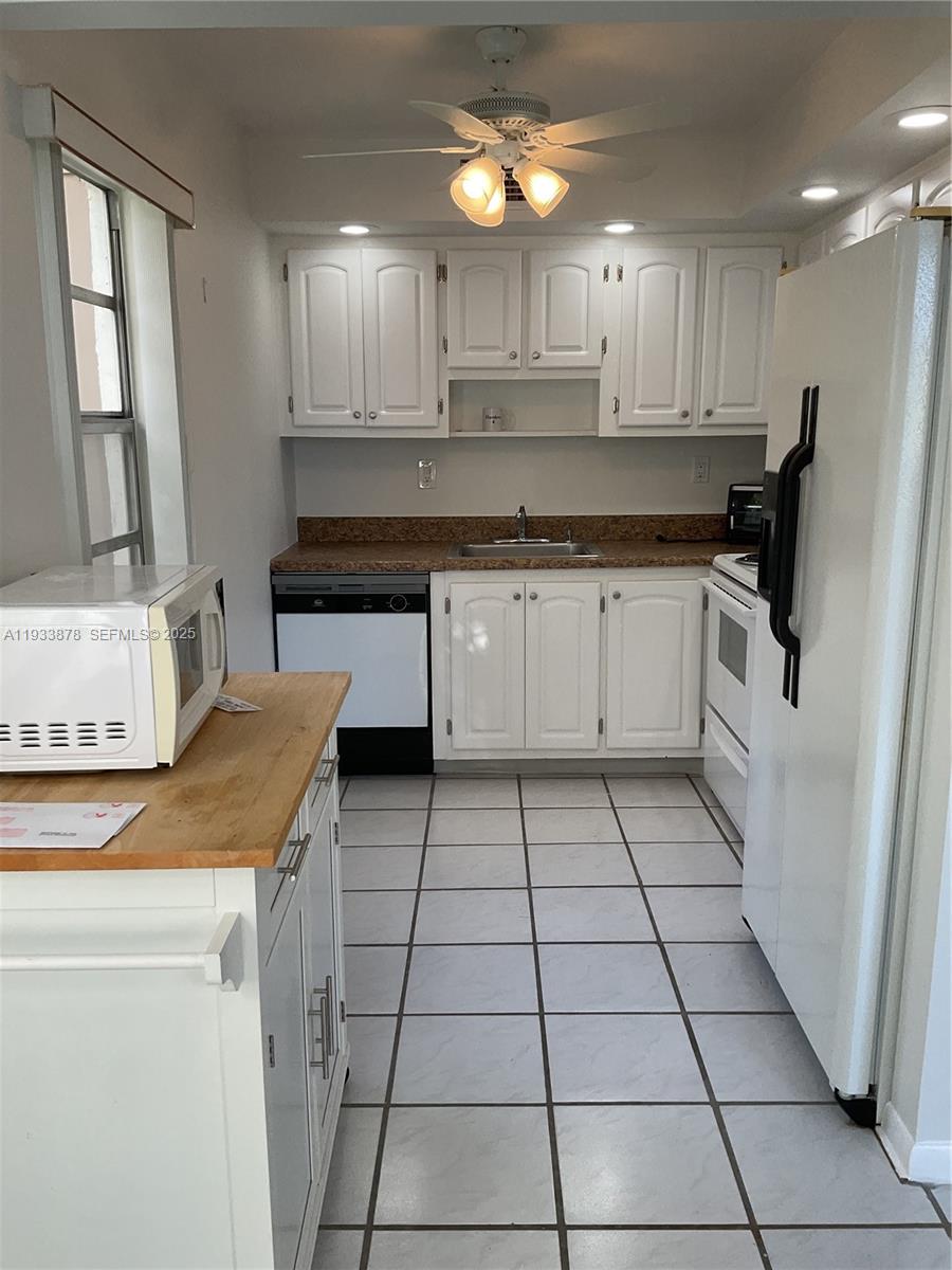485 Flanders P, Unit 485 Delray Beach, FL 33484 - Photo 8 of 42 a kitchen with stainless steel appliances granite countertop a sink a stove a refrigerator and cabinets