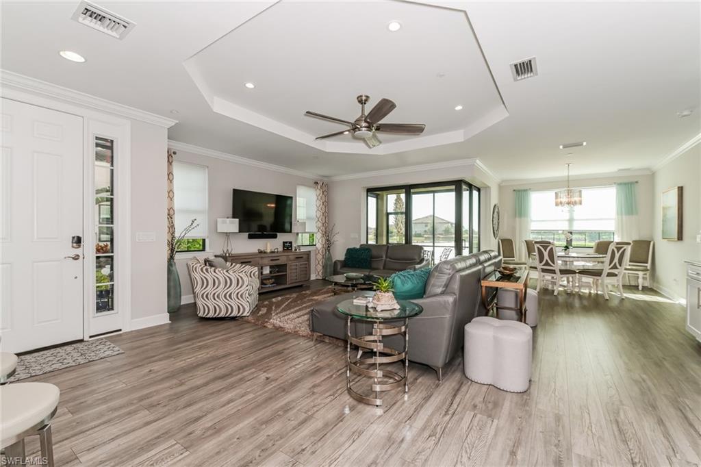 9636 Montelanico Loop, Unit 101 Naples, FL 34119 - Photo 2 of 10 Living room featuring a tray ceiling, ornamental molding, a ceiling fan, light wood-type flooring, and recessed lighting