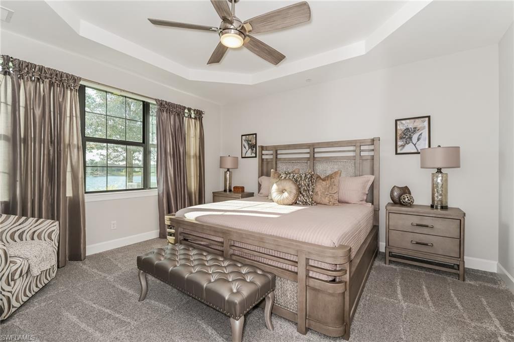 9636 Montelanico Loop, Unit 101 Naples, FL 34119 - Photo 7 of 10 Carpeted bedroom with a tray ceiling and a ceiling fan