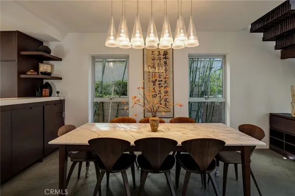 a dining room with a table chairs and a kitchen view