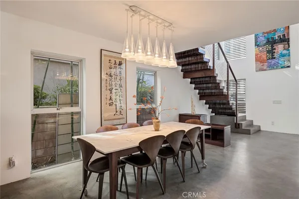 a dining room with furniture a chandelier and window