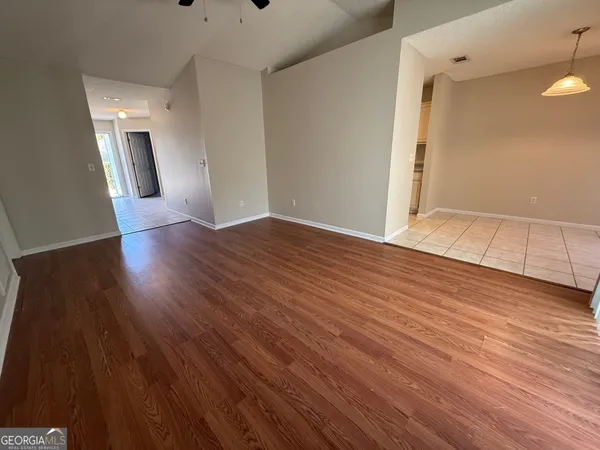 an empty room with wooden floor and mirror