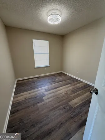 an empty room with a wooden floor and a window
