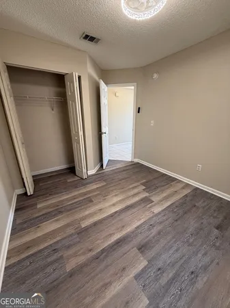 an empty room with wooden floor and entrance
