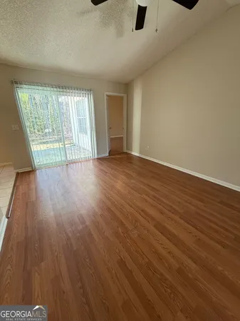 an empty room with wooden floor and windows