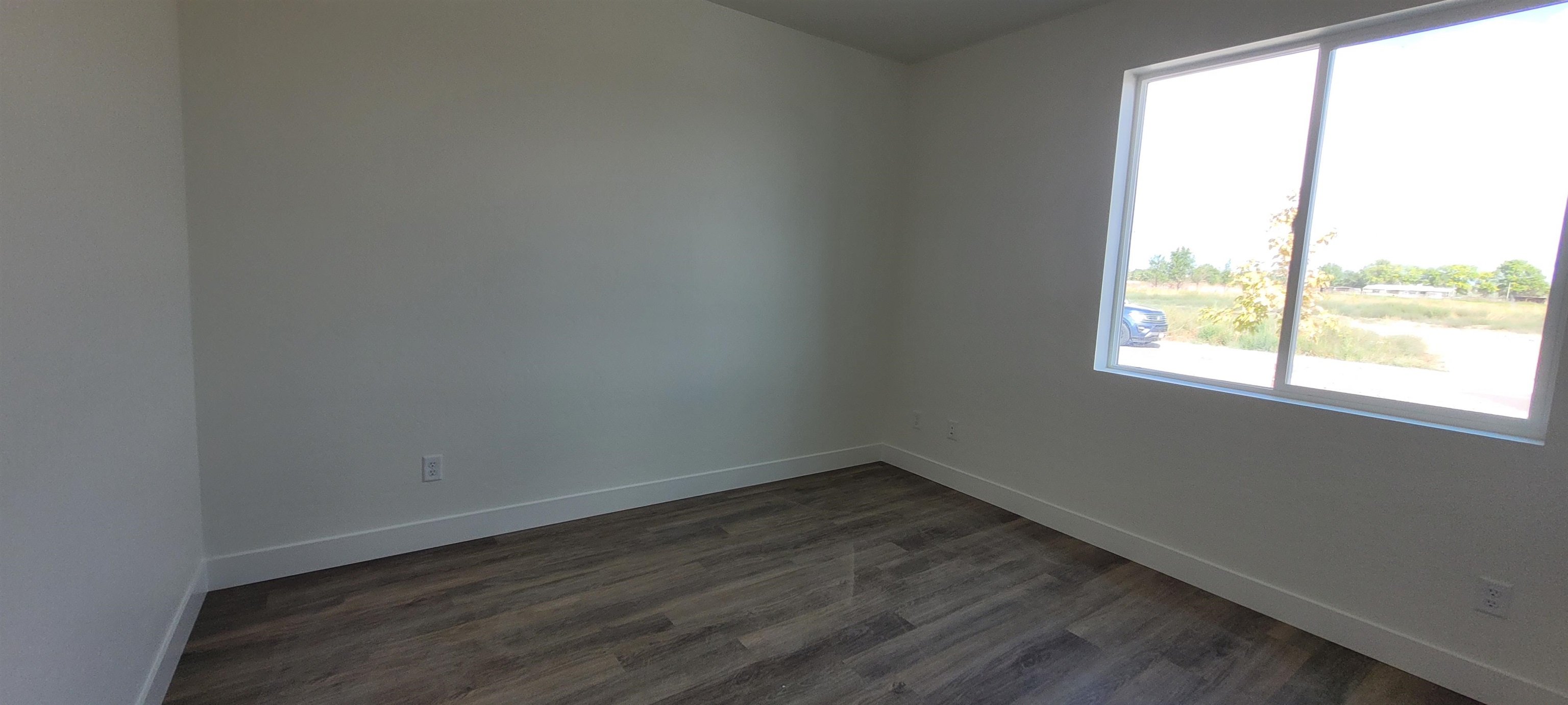 1674 Tungsten Way Fruita, CO 81521 - Photo 7 of 17 an empty room with wooden floor and windows