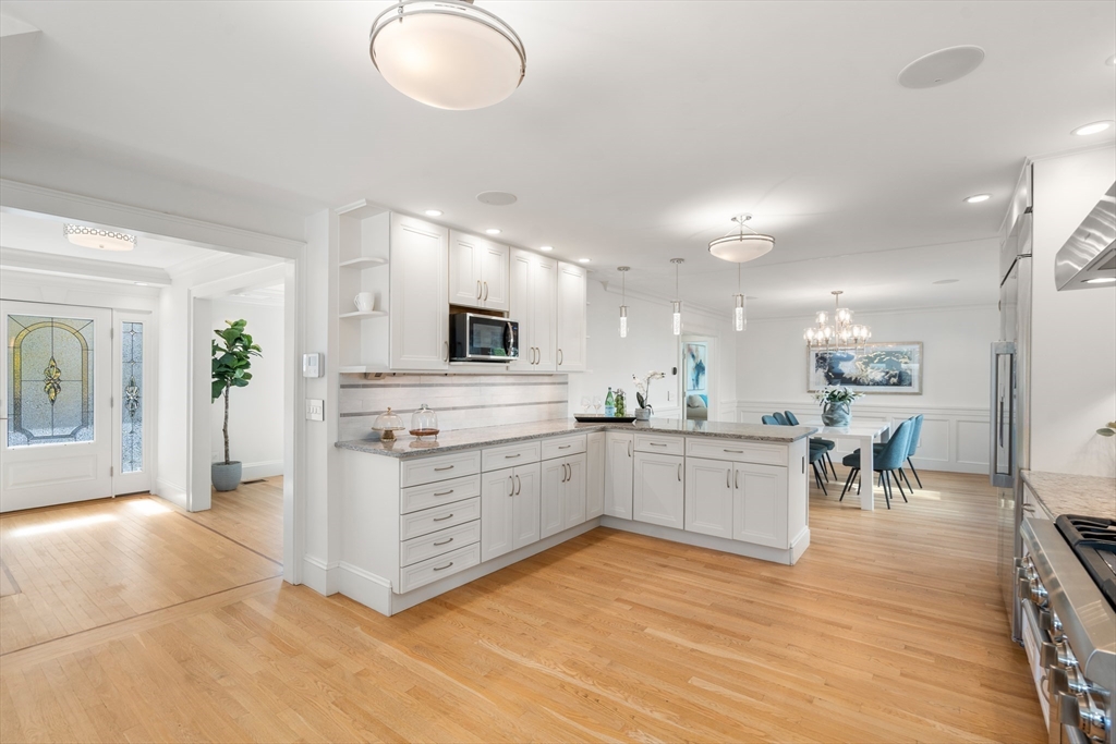 152 Bellevue Road Watertown, MA 02472 - Photo 7 of 42 a kitchen with stainless steel appliances granite countertop a stove a sink a refrigerator and white cabinets with wooden floor