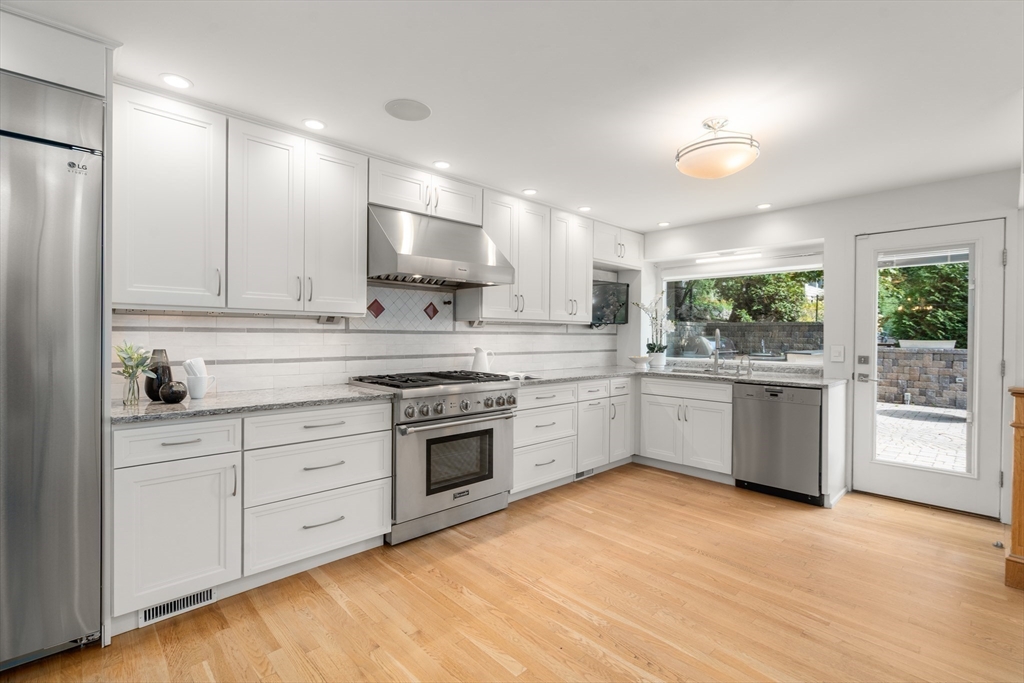 152 Bellevue Road Watertown, MA 02472 - Photo 9 of 42 a kitchen with stainless steel appliances white cabinets a sink a stove a refrigerator and a microwave