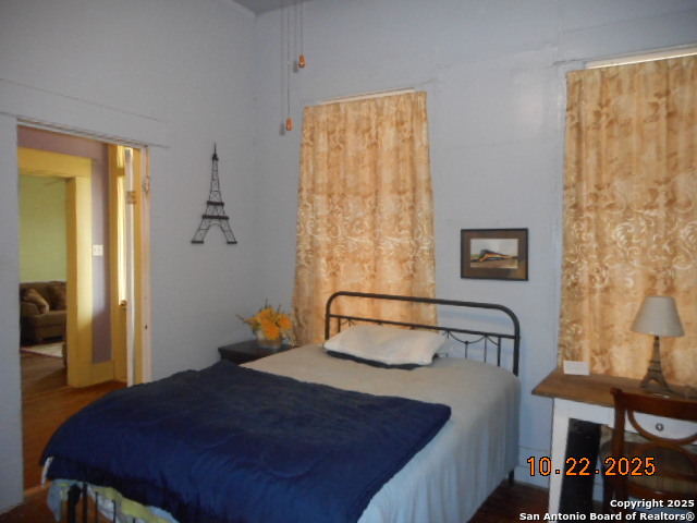 1212 Magnolia Street Jourdanton, TX 78026 - Photo 9 of 14 a bedroom with a bed and wooden floor