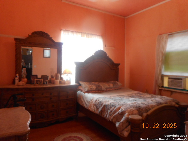 1212 Magnolia Street Jourdanton, TX 78026 - Photo 10 of 14 a bedroom with a bed and a dresser with mirror