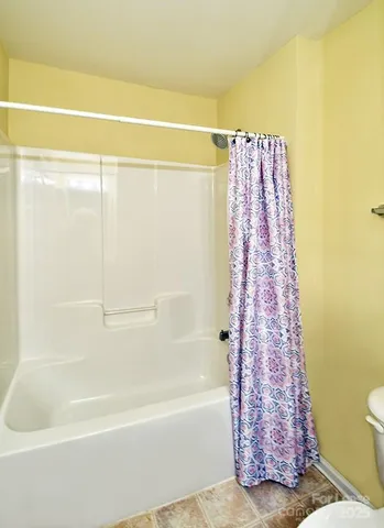 a bathroom with a shower curtain and a bath tub