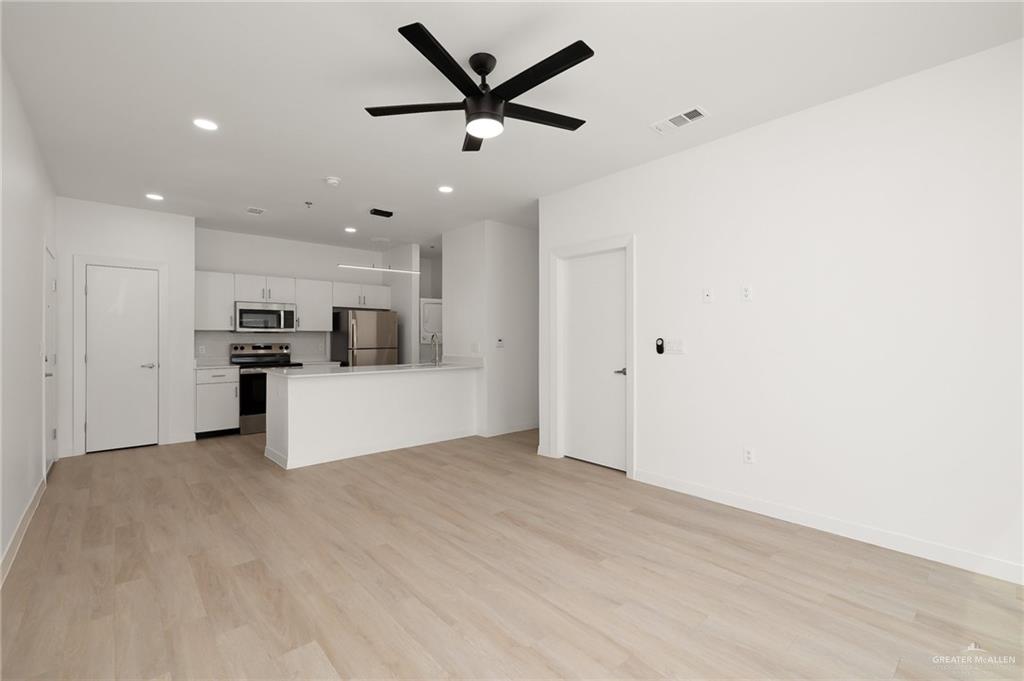 412 South Ware Road McAllen, TX 78501 - Photo 4 of 7 Unfurnished living room with light hardwood / wood-style flooring and ceiling fan