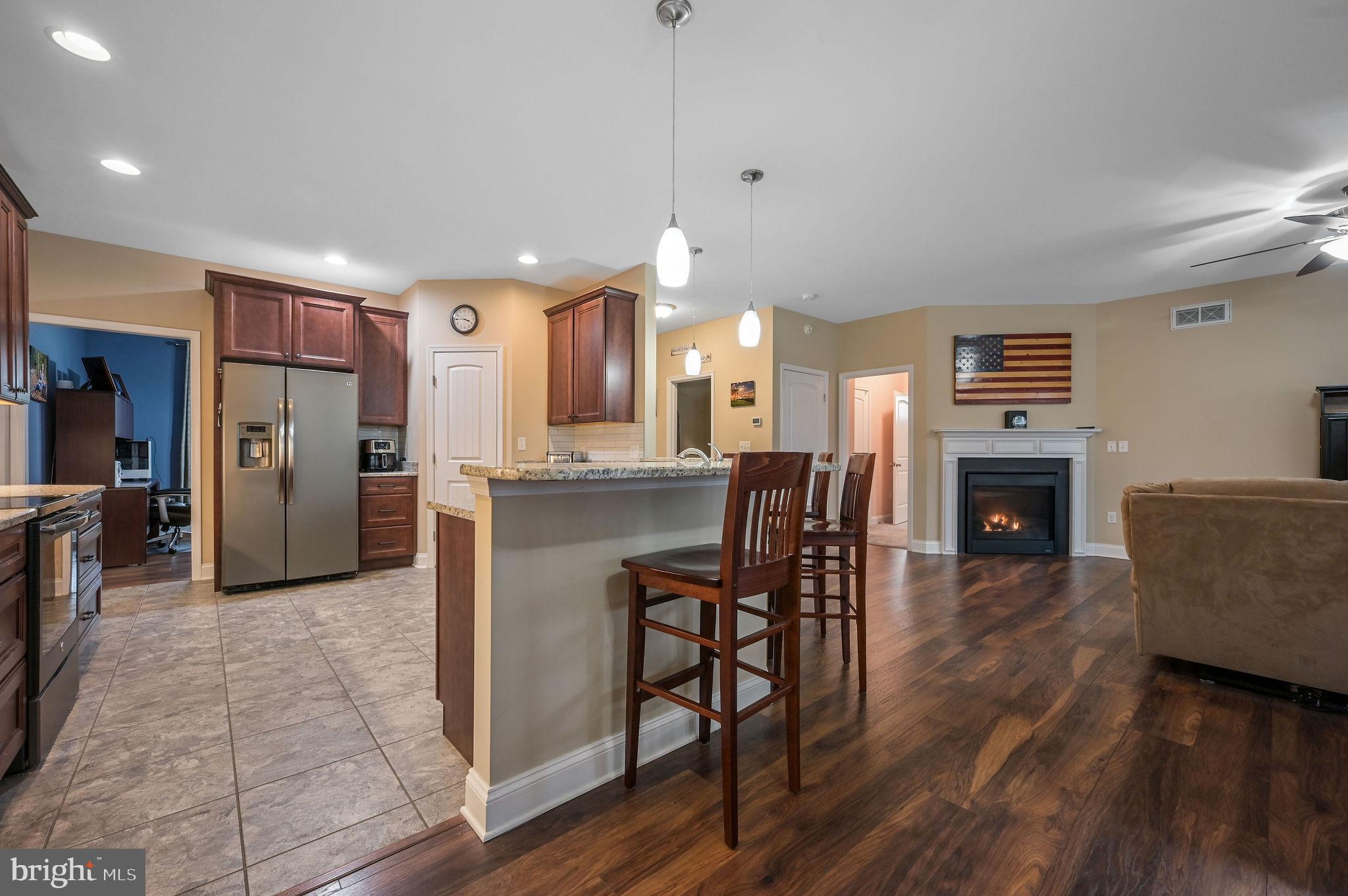 321 Blue Heron Road Dover, DE 19904 - Photo 21 of 47 a living room with furniture a fireplace and a kitchen view
