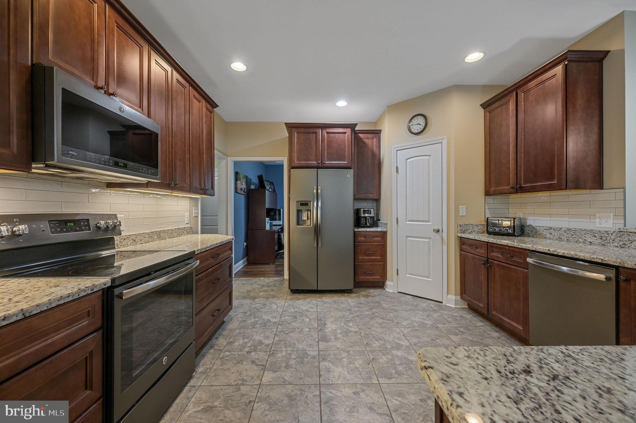 321 Blue Heron Road Dover, DE 19904 - Photo 23 of 47 a kitchen with stainless steel appliances granite countertop a refrigerator and a stove top oven