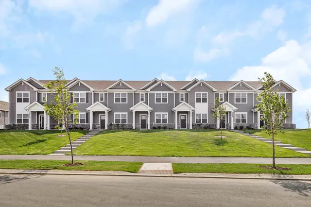 a view of a big house with a big yard and large trees