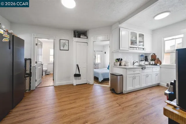 a kitchen with a refrigerator cabinets and wooden floor