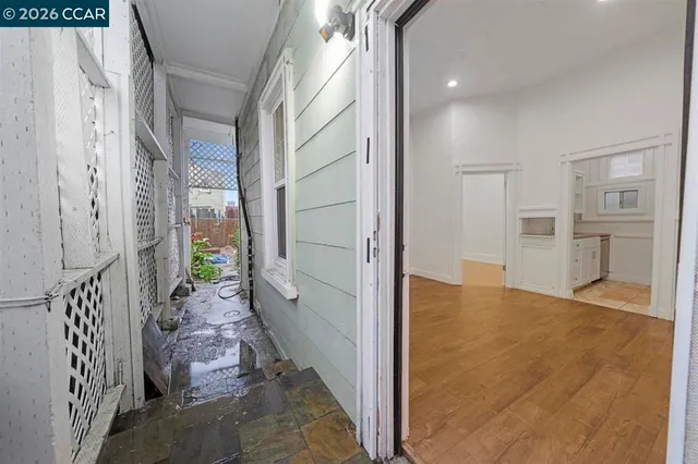 a view of empty room with wooden floor and window