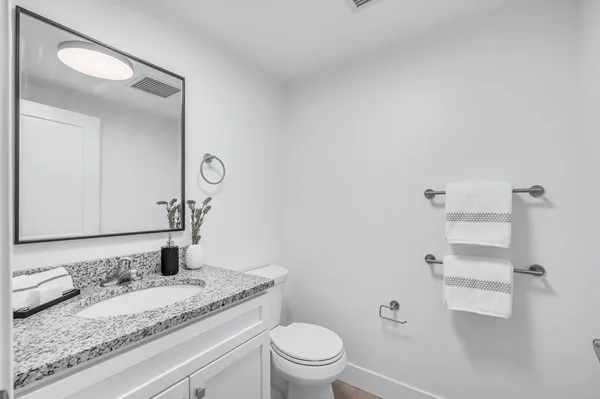 a bathroom with a granite countertop sink and a mirror