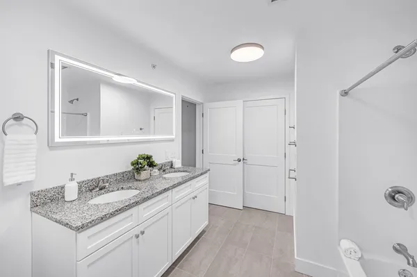 a bathroom with a granite countertop sink and a mirror