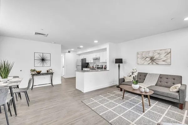 a living room with furniture and view of kitchen