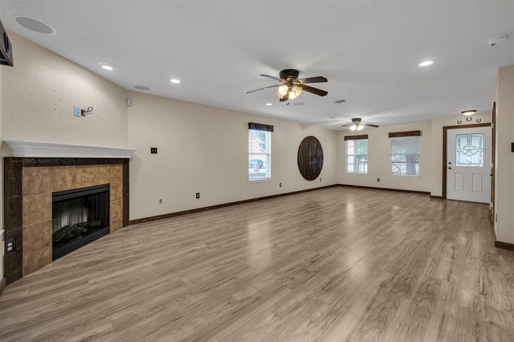 9017 Graywolf Ridge Trail Fort Worth, TX 76244 - Photo 27 of 27 Unfurnished living room with wood-type flooring, ceiling fan, and a tile fireplace