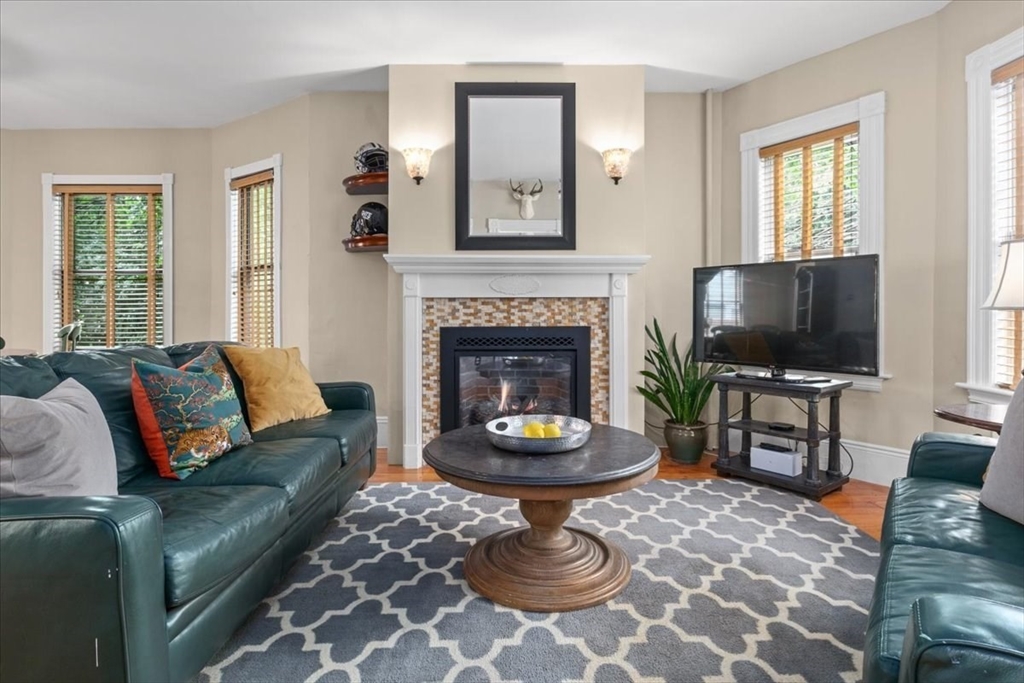 265 Sutton Street North Andover, MA 01845 - Photo 5 of 27 a living room with furniture a flat screen tv and a fireplace