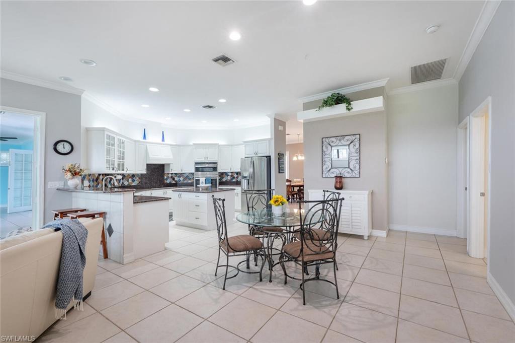 9974 Boca Avenue North Naples, FL 34109 - Photo 18 of 42 a kitchen with a dining table chairs and view of living room