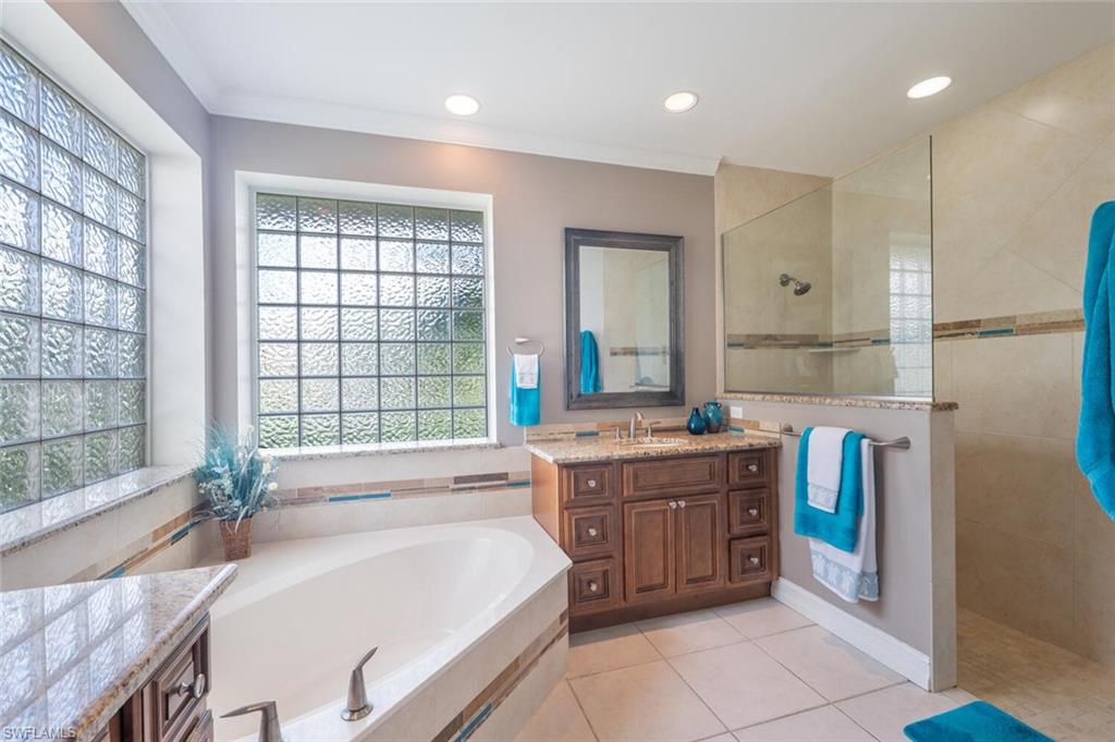 9974 Boca Avenue North Naples, FL 34109 - Photo 27 of 42 a spacious bathroom with a granite countertop tub sink shower and mirror