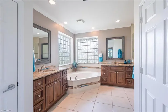 a spacious bathroom with a granite countertop tub sink and mirror