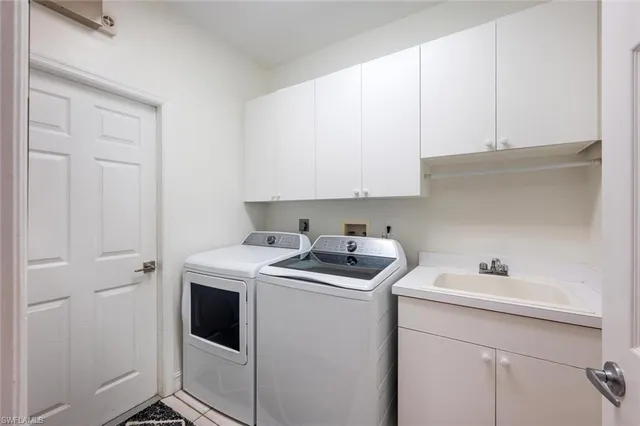 a utility room with sink dryer and washer
