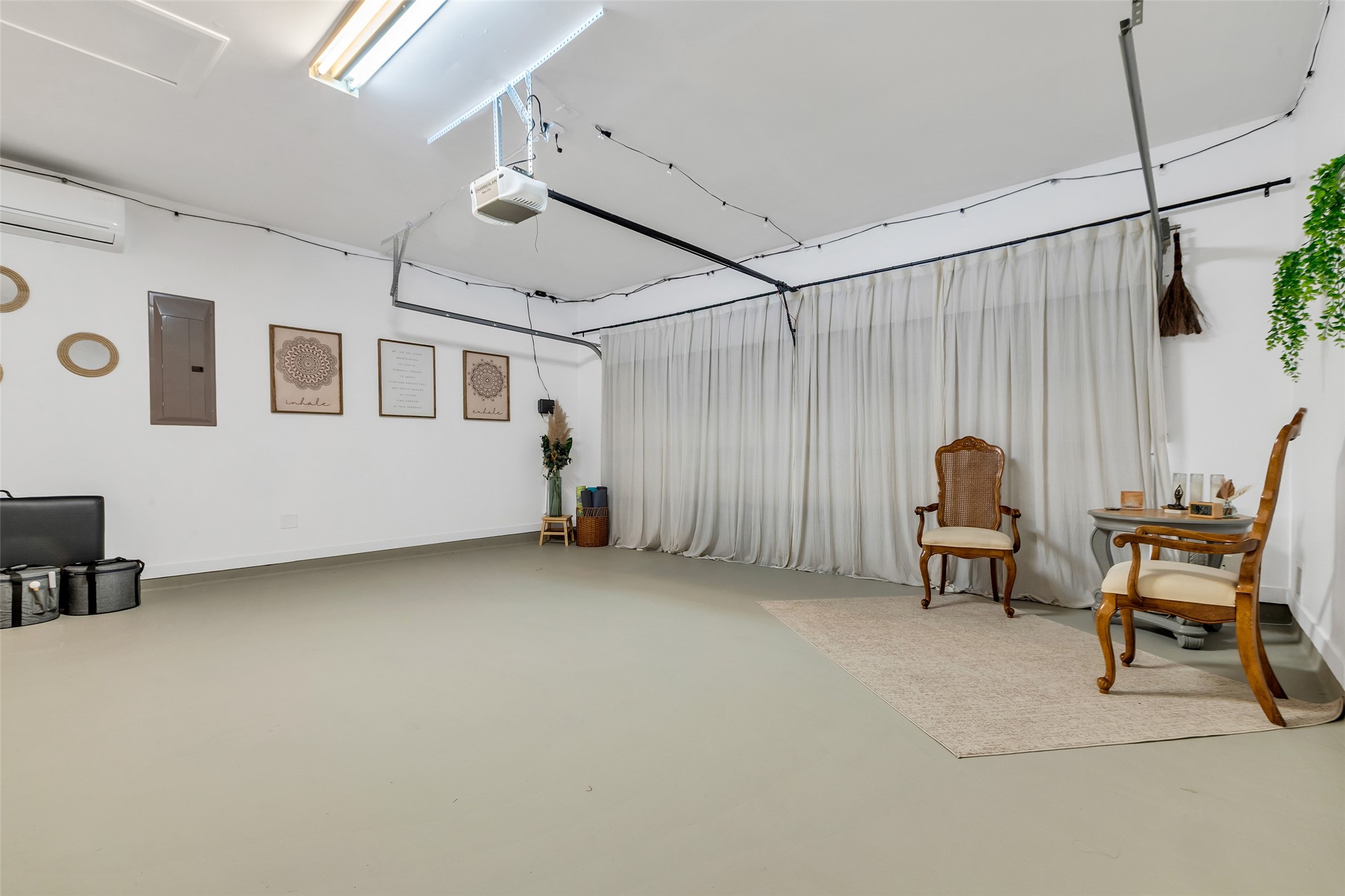 155 Magnolia Grove Lane Conroe, TX 77384 - Photo 21 of 25 Garage features neutral tones and a clean aesthetic with light walls and floors, plus air conditioning, making it ideal for a versatile living, workspace, or recreational area.