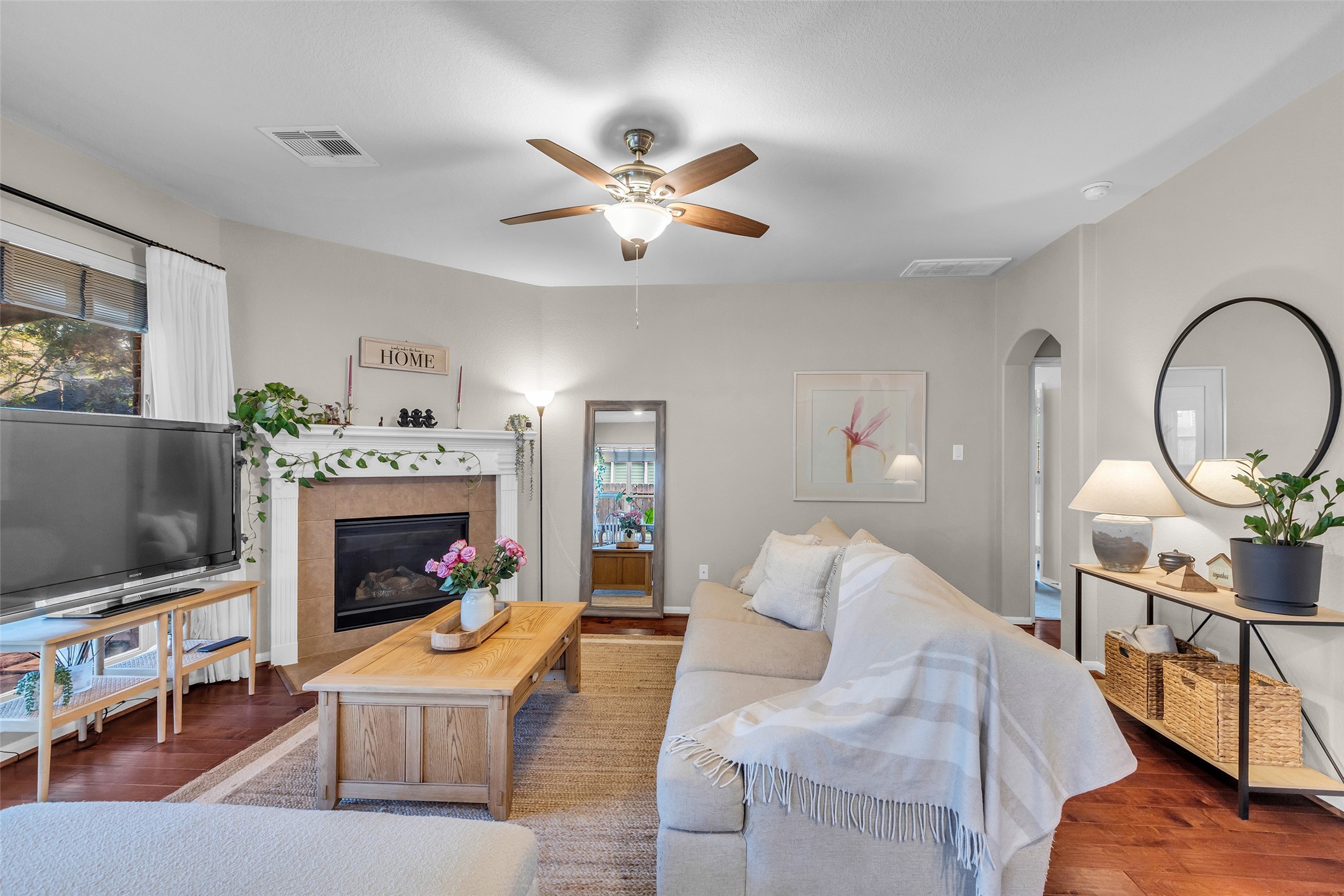 155 Magnolia Grove Lane Conroe, TX 77384 - Photo 5 of 25 Living room with natural light streams in through large windows, creating a warm and inviting atmosphere.