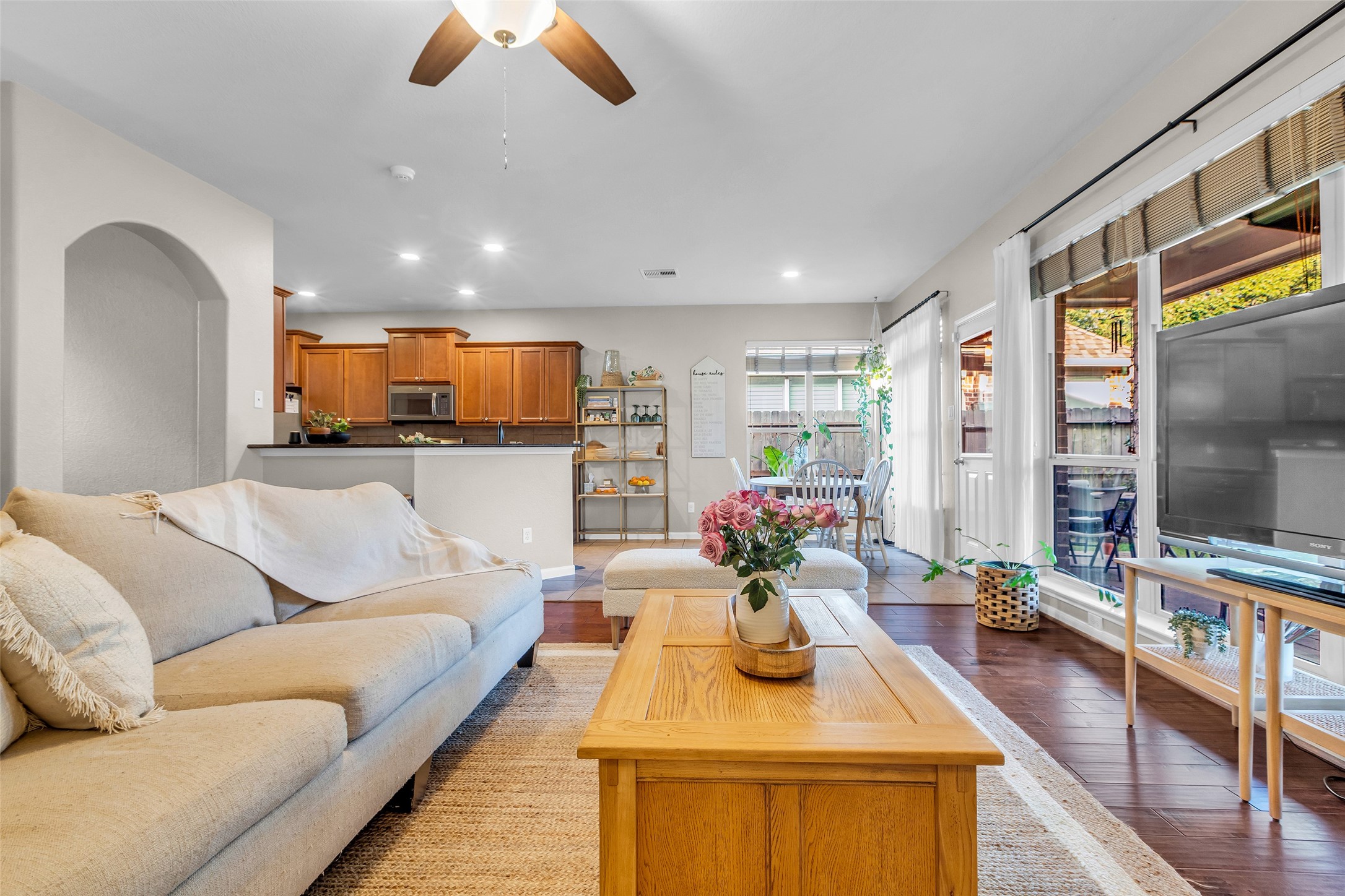 155 Magnolia Grove Lane Conroe, TX 77384 - Photo 25 of 25 Inviting living space features an open floor plan with a cozy seating area, wood flooring, and abundant natural light from large windows