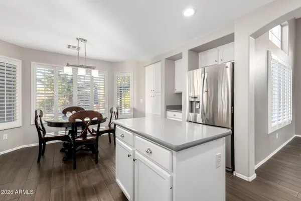 a kitchen with stainless steel appliances granite countertop a table chairs and a refrigerator