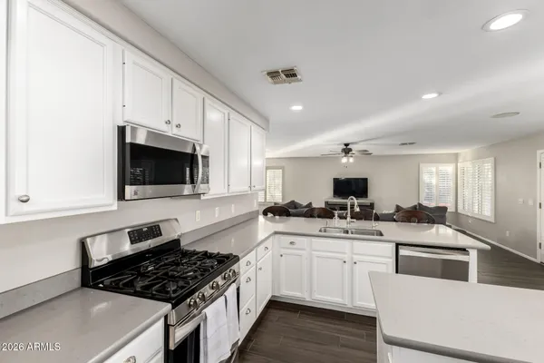 a kitchen with white cabinets and appliances