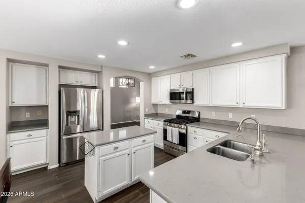 a kitchen with stainless steel appliances granite countertop a refrigerator sink and stove