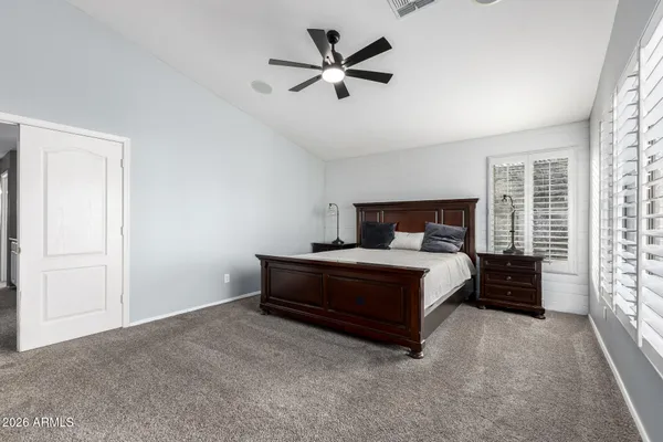 a bed sitting in a spacious bedroom next to a window