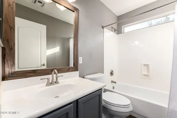 a front view of a house with a garden and trees