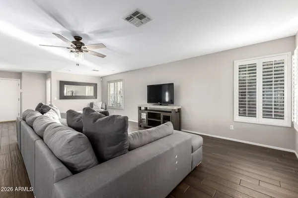 a living room with furniture ceiling fan and a window