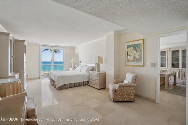a spacious bedroom with a bed and glass window