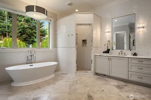 a spacious bathroom with a double vanity sink a mirror and a bathtub