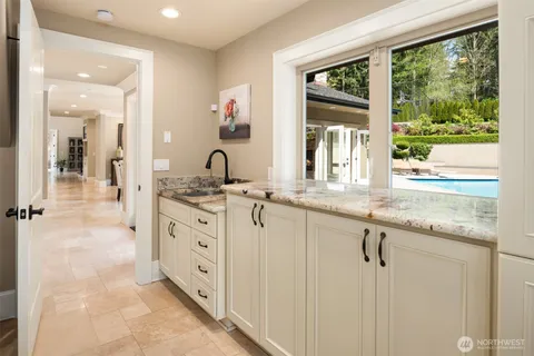 a bathroom with a granite countertop sink mirror and a window