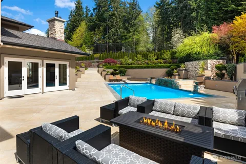 a roof deck with couches and a potted plant on a table
