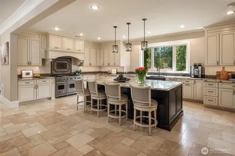 a kitchen with kitchen island granite countertop a sink counter top space appliances and a center island