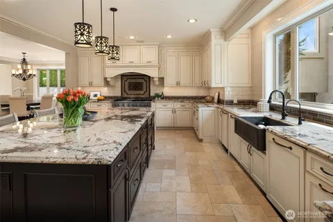 a kitchen with kitchen island granite countertop a sink stove and cabinets